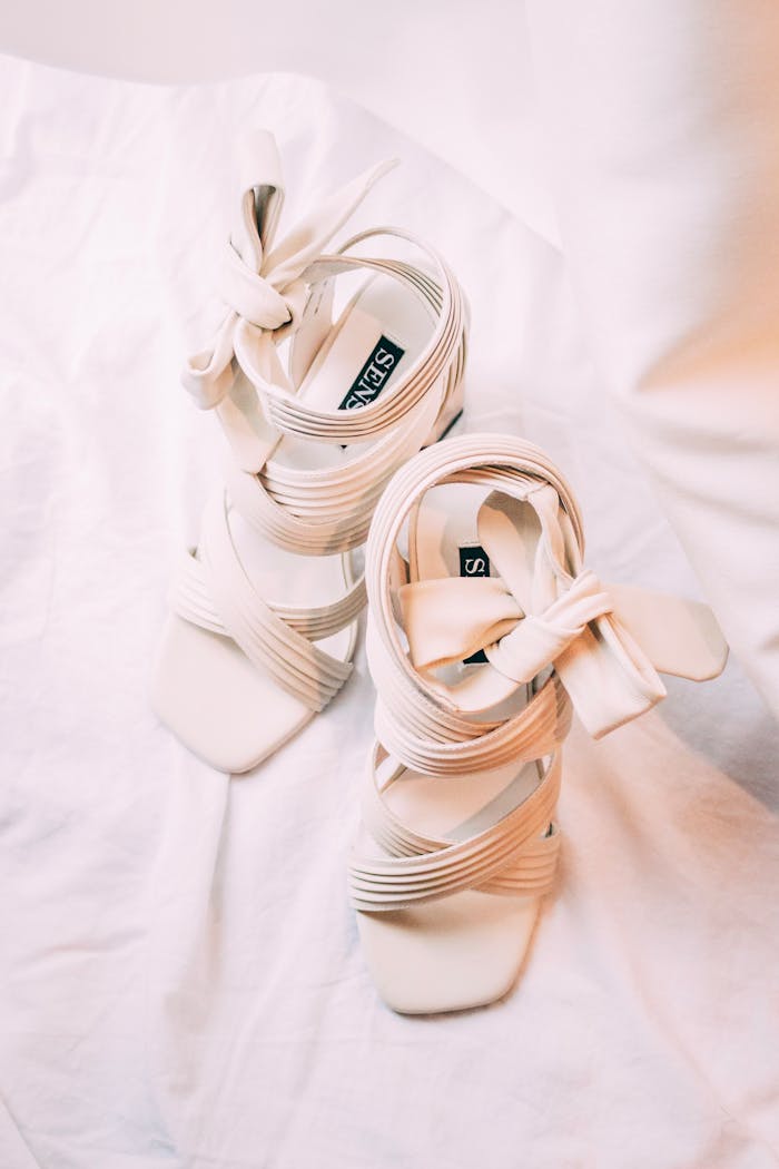 Stylish white high-heeled shoes on a soft fabric background, exuding elegance and femininity.